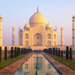 Taj Mahal Architecture – Secrets of the Monument of Love, Complete Guide 2025 Taj Mahal with its white marble dome and minarets reflecting in the central pool at sunrise in Agra, India
