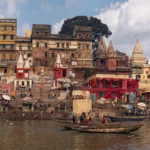 Varanasi Tourism – The Eternal City of Lord Shiva Panoramic view of Varanasi ghats with historic temples, colourful buildings, and boats on the Ganges
