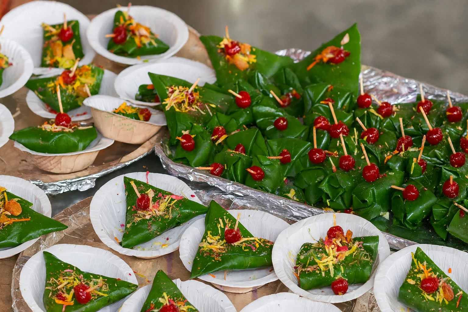 Traditional Banarasi Paan – A Sweet Cultural Delight Banarasi paan neatly arranged on plates and trays with cherries and toppings