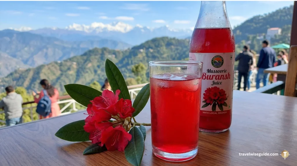 Mussoorie Buransh: A Taste Of Himalayan Spring Buransh juice glass with red flowers against snowy mountain peaks.