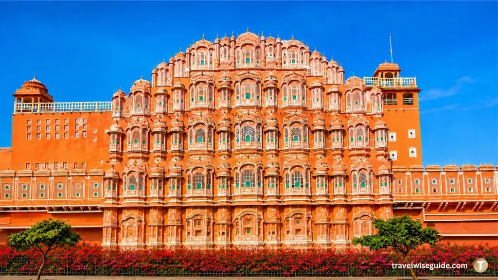 Hawa Mahal Jaipur Pink City Landmark Hawa Mahal Jaipur facade with flower beds, trees and blue sky