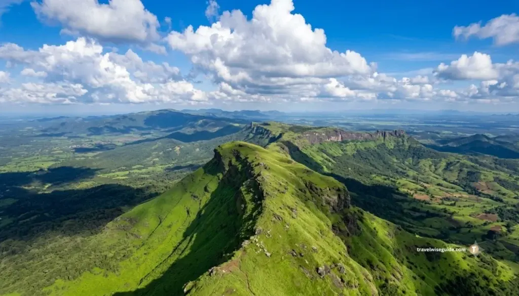Kemmanagundi: Breath-taking Western Ghats Splendour Kemmanagundi mountain ridge showcasing panoramic lush valley under scattered clouds.